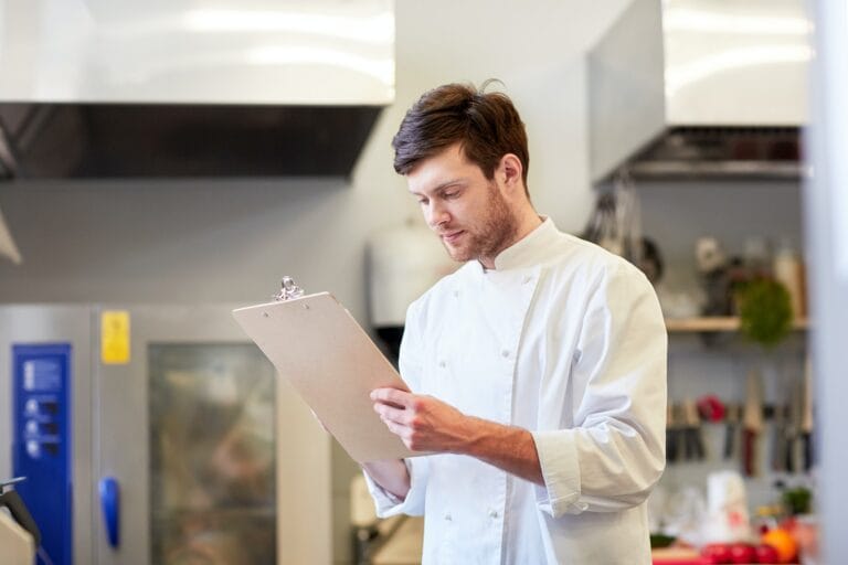 chef with clipboard doing inventory at restaurant